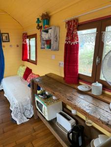 Zimmer mit einem Bett und einem Tisch in einem Zimmer in der Unterkunft Roulotte "Grain de Folie" in Waben