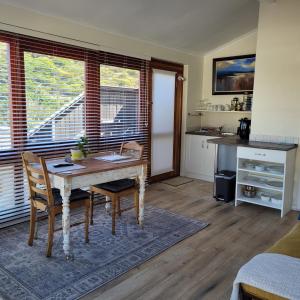 a kitchen with a wooden table and chairs in a room at Leehaven Apartment in Hout Bay