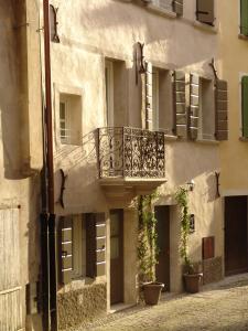 a building with a balcony and potted plants on it at Residenza Dei Tolomei Polcenigo in Polcenigo