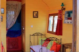sypialnia z łóżkiem i oknem w obiekcie Roulotte "Grain de Folie" w mieście Waben