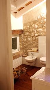 uma casa de banho em pedra com um lavatório e um WC em Residenza Dei Tolomei Polcenigo em Polcenigo