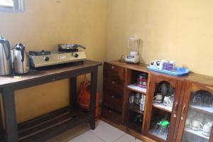 une cuisine avec deux tables en bois et un mixeur dans l'établissement Kibale Eco-Home, à Bigodi
