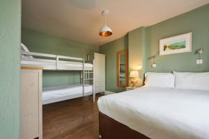 a bedroom with two bunk beds and a bed at Oystercatcher Apartments in Polzeath