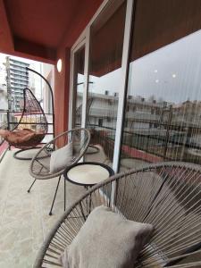 a balcony with chairs and a hammock on a building at Apartament Ella T8 in Mamaia Sat/Năvodari
