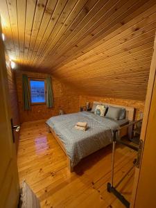 a bed in a room with a wooden ceiling at NuA House "Kapri" in Gornji Štoj