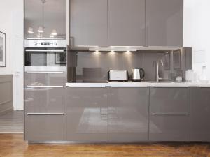 una cocina con electrodomésticos de acero inoxidable y armarios blancos en LivinParis - Luxury 2 Bedrooms Grands-Boulevards I, en París