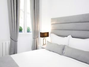 - une chambre blanche avec un lit et une fenêtre dans l'établissement LivinParis - Luxury 2 Bedrooms Grands-Boulevards I, à Paris