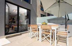 een tafel en stoelen en een parasol op een patio bij Casa Cocoon in Funtana