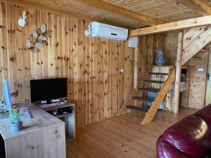 a living room with a staircase in a wooden cabin at NuA House "Kapri" in Gornji Štoj
