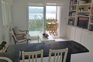a living room with a table and a view of the ocean at Coqueto apartamento en Raxó, Sanxenxo in Raxó