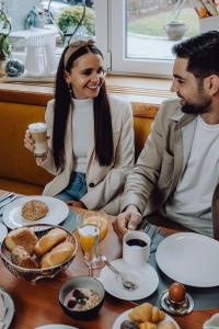 Ein Mann und eine Frau sitzen an einem Tisch mit Essen in der Unterkunft Boutique Hotel Diana in Bad Füssing
