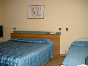 een slaapkamer met een bed en een telefoon aan de muur bij Hotel Garden in Tirrenia