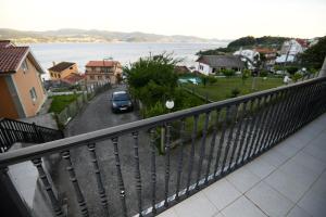 balcone con vista su una strada e sull'acqua di Coqueto apartamento en Raxó, Sanxenxo a Raxó