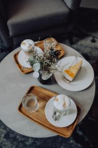 - une table avec des assiettes et des tasses sur un plateau en bois dans l'établissement Boutique Hotel Diana, à Bad Füssing