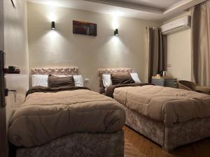 two beds in a hotel room with two beds at Pyramids Gardens Hotel - فندق حدائق الاهرام in Cairo