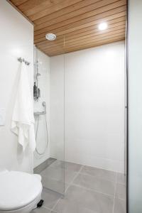 uma casa de banho com um WC e uma porta de duche em vidro. em Kaunis ja toimiva uusi yksiö em Kuopio