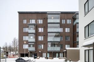 een appartementencomplex met sneeuw ervoor bij Kaunis ja toimiva uusi yksiö in Kuopio