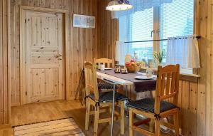 cocina con mesa, sillas y ventana en 1 Bedroom Stunning Apartment In Hauge I Dalane en Sogndalsstrand