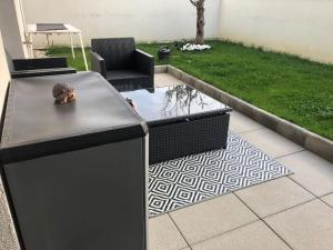 une terrasse avec une table, des chaises et un étang dans l'établissement Appartement avec jardin et terrasse couverte, à Voreppe