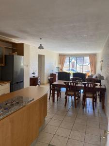 a kitchen and living room with a table and chairs at On the Beach in Hout Bay