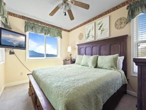 a bedroom with a large bed and two windows at Deer Ridge Mountain Resort D204 in Gatlinburg