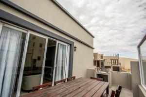 - un balcon avec une table et des chaises en bois dans un bâtiment dans l'établissement Long Beach Selfcatering Namibia, à Langstrand