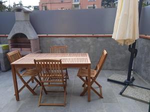 a wooden table and chairs and an umbrella on a patio at La Villetta Sull'Argine in Imperia