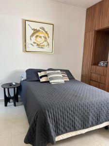 sypialnia z łóżkiem z czarną kołdrą w obiekcie Hermoso Departamento Bracco w mieście Alvarado