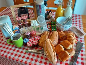 un tavolo sormontato da pane e altro cibo su un tavolo di Le Relais du Jardin a Orbigny