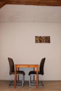 una mesa con dos sillas y una foto en la pared en Grand Apartments Kassel, en Calden