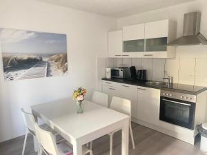 a kitchen with a white table and chairs and a kitchen with a beach at Gemütliches Zuhause in 1A Lage in Herne