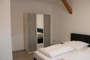 a bedroom with a mirror next to a bed at Grand Apartments Kassel in Calden