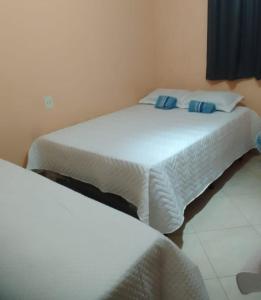 two beds with blue pillows in a room at Apart Hotel big john 101 Vista para rua in Divinópolis