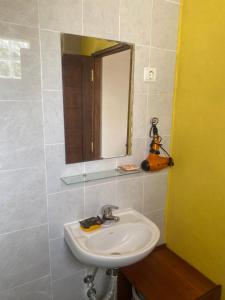 a bathroom with a sink and a mirror at Studio Espiral in São Tomé