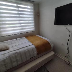 a bedroom with a bed and a flat screen tv at Departamento Puerto Varas in Puerto Varas