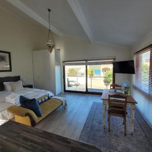 1 dormitorio con cama, escritorio y mesa en Leehaven Apartment en Hout Bay