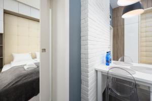 a bedroom with a bed and a sink at Caramel by OneApartments in Sopot