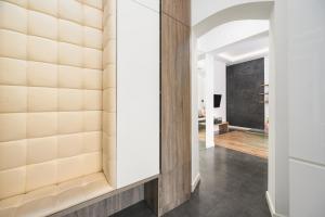 a hallway with a wall of wood and a mirror at Caramel by OneApartments in Sopot