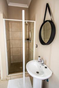 La salle de bains est pourvue d'un lavabo et d'une douche. dans l'établissement Long Beach Selfcatering Namibia, à Langstrand