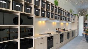 uma grande cozinha com armários brancos e electrodomésticos pretos em Capsuleaccom Hostel em Gold Coast