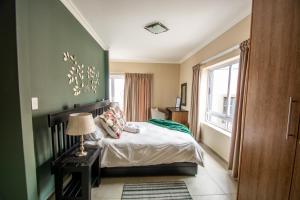 a bedroom with a bed with a green wall at Long Beach Selfcatering Namibia in Langstrand