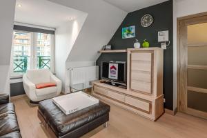 ein Wohnzimmer mit einem Sofa, einem Stuhl und einem TV in der Unterkunft Triniteyt 0302 P7 in Nieuwpoort