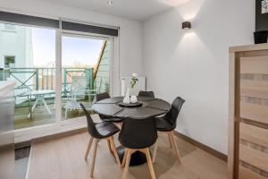 ein Esszimmer mit einem Tisch und Stühlen sowie einem Balkon in der Unterkunft Triniteyt 0302 P7 in Nieuwpoort