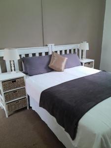 a bedroom with a large bed and two night stands at UNDERBERG INN in Underberg