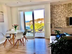 a living room with a table and chairs and a balcony at Beautiful view apartment with garage space in Mali Lošinj