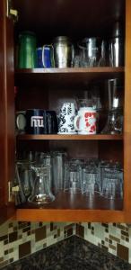 une étagère remplie de beaucoup de tasses et de bols dans l'établissement A comfy place in queens, à Cambria Heights