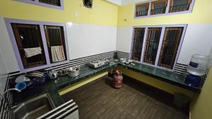 a kitchen with a counter with a sink and windows at Balaji Homestay in Guwahati