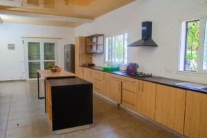 cocina con armarios de madera y encimera negra en 3 bedrooms villa with private pool terrace and wifi at Antisiranana 5 km away from the beach, en Antsiakambony