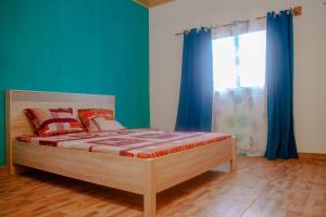 Schlafzimmer mit einem Bett mit blauen Wänden und einem Fenster in der Unterkunft 3 bedrooms villa with private pool terrace and wifi at Antisiranana 5 km away from the beach in Antsiakambony