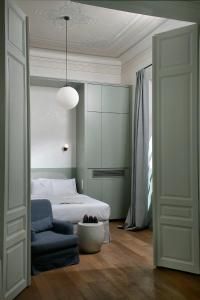 雅典的住宿－Exquisite Athens Apartment | 1 Bedroom | Apartment Metalicana | Balcony | Athinaidos，一间卧室配有一张床、一把椅子和一张沙发
